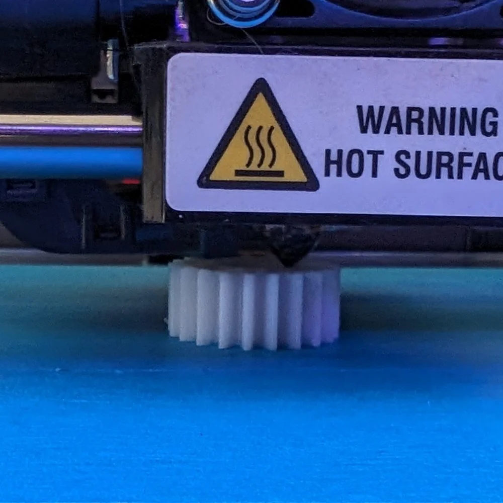 The gear being printed in a 3D printer